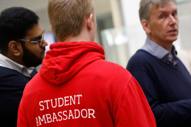 Photo from the back with the volunteer wearing the University of Salford red student ambassdor hoodie