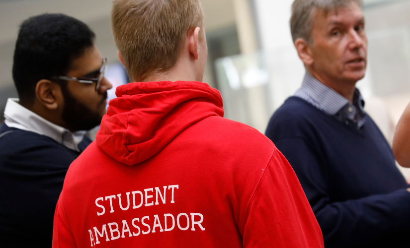 Photo from the back with the volunteer wearing the University of Salford red student ambassdor hoodie